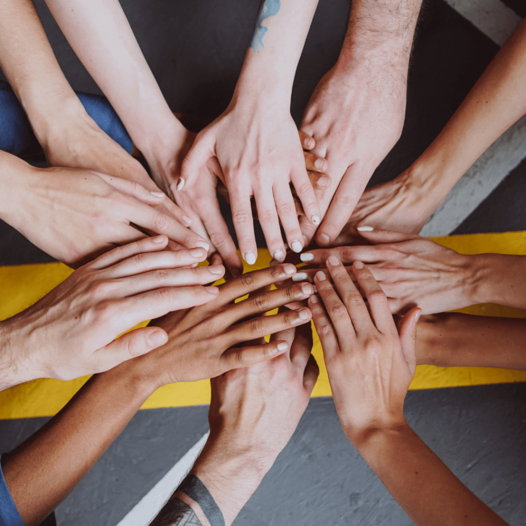 Gruppe Menschen legt ihre Hände aufeinander